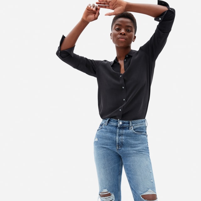 Black silk button down shirt and blue jeans.